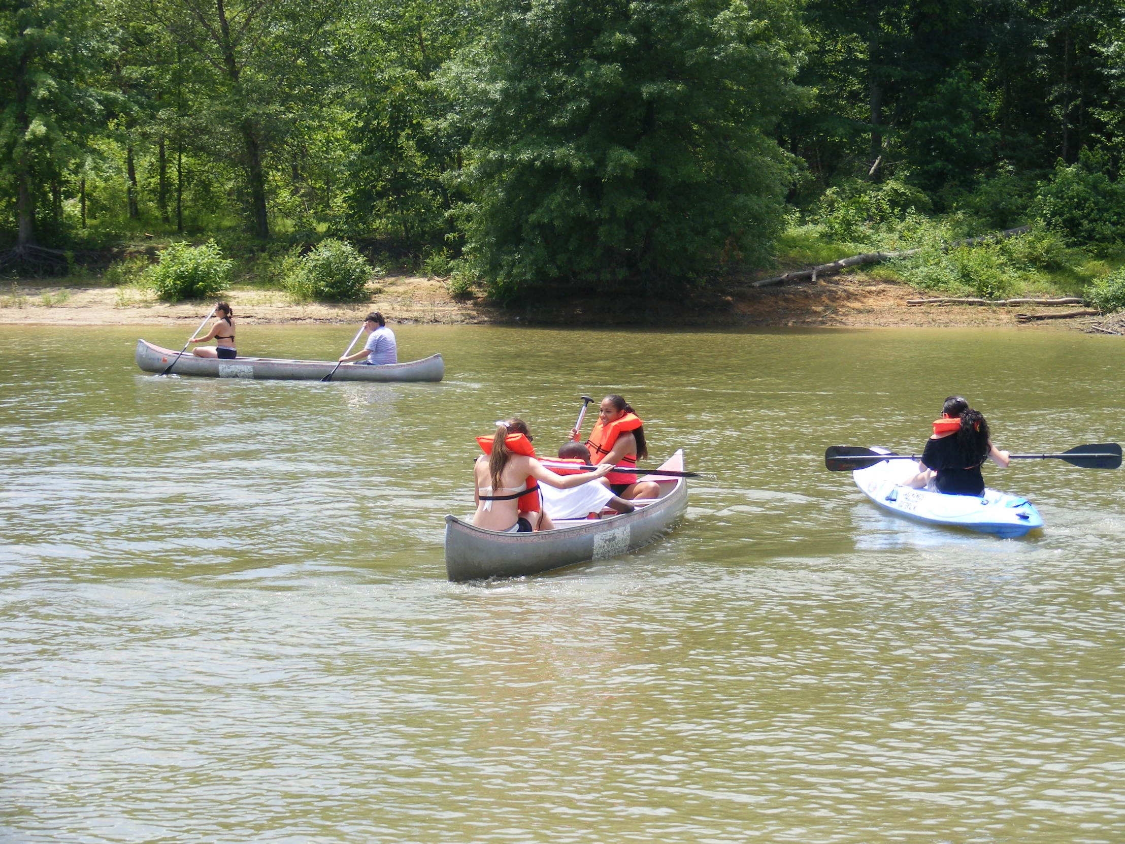 three canoers and two kayakers are on the water