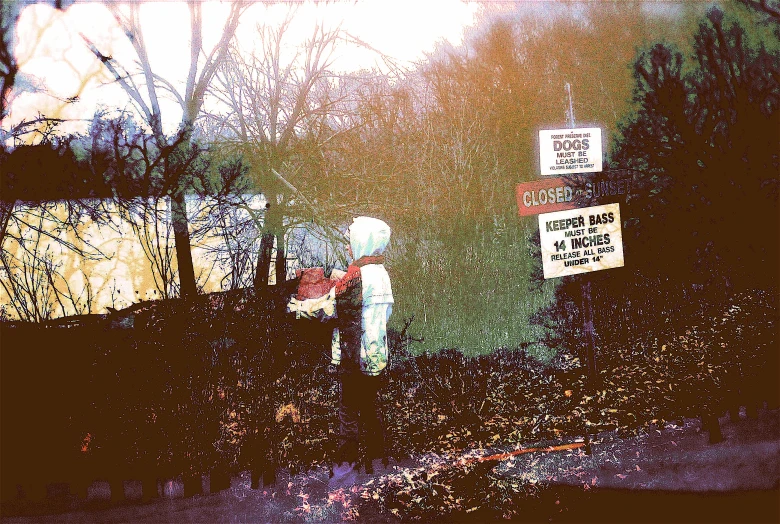 two people are standing in the rain next to the street sign