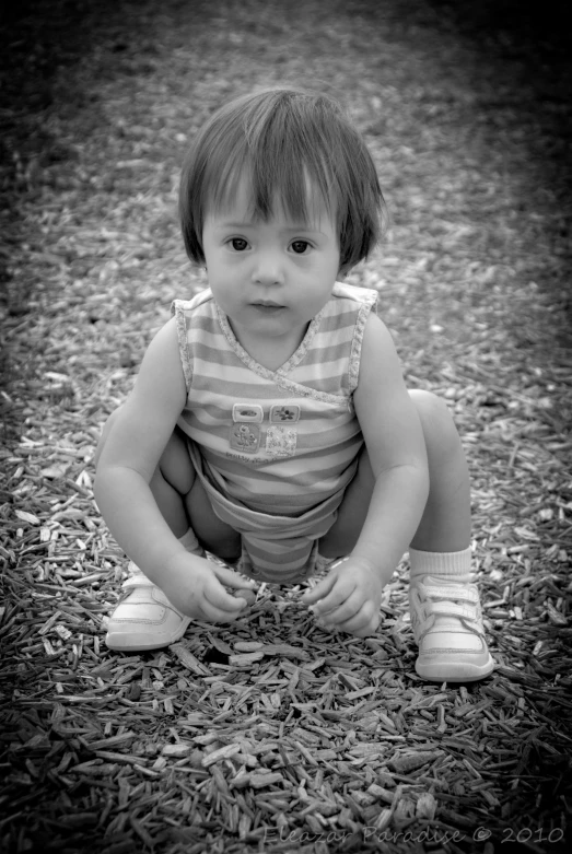 a small child kneeling on some grass