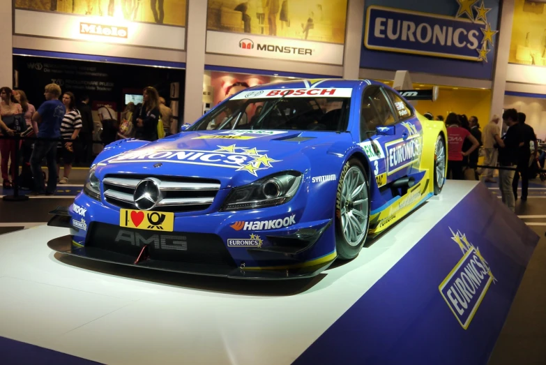 a blue racing car sitting on top of a show floor