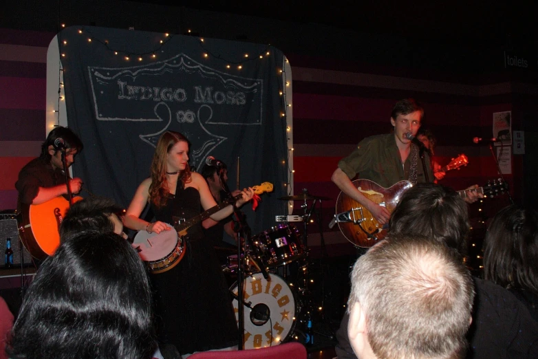 a group of people standing next to each other with guitars