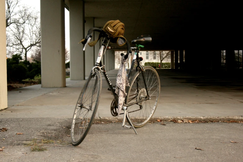 a bicycle parked under an overpass in front of building