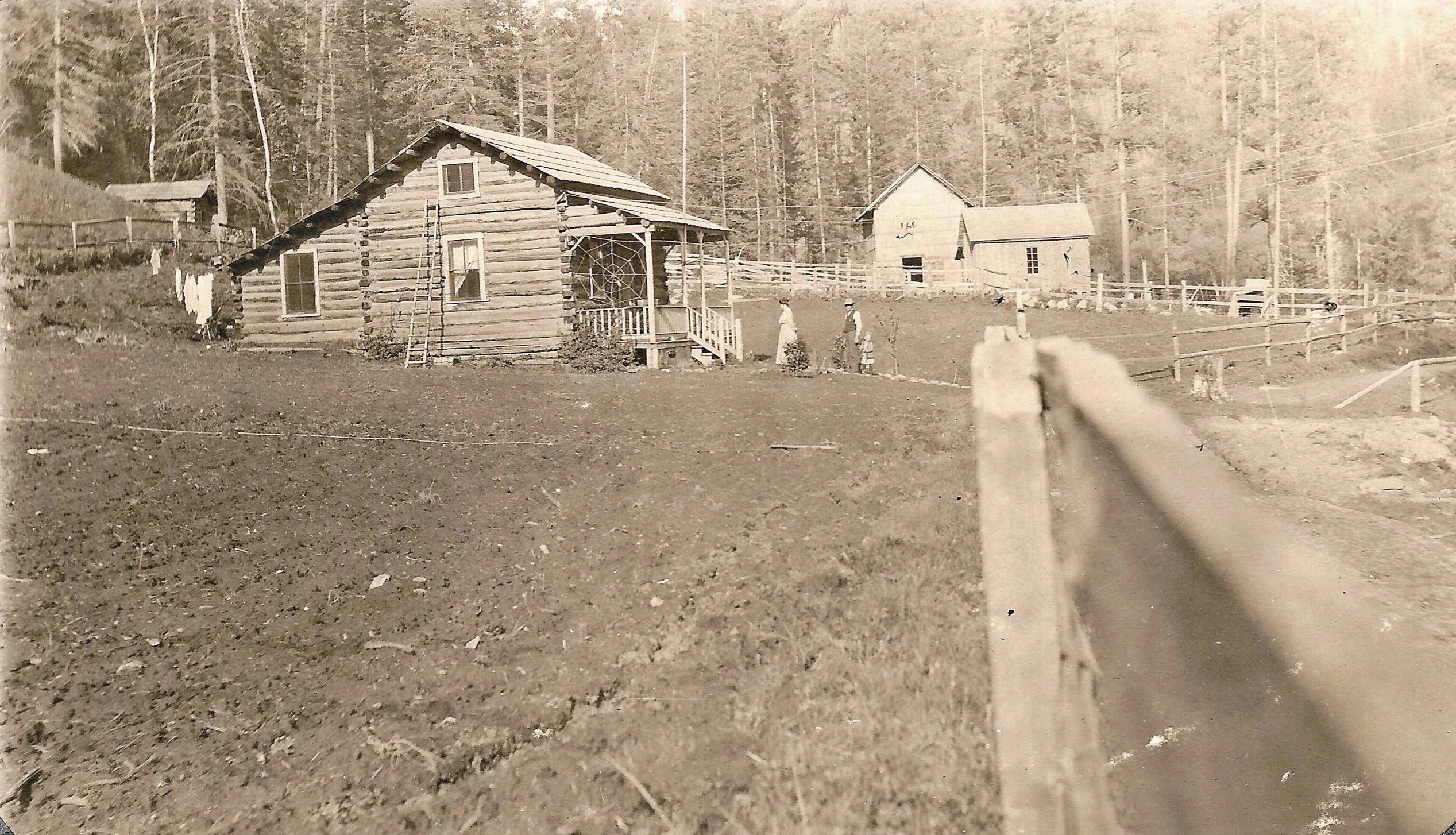 old po of a dirt field and house near forest