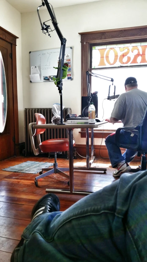 a man sitting in a chair next to a bike in front of a camera