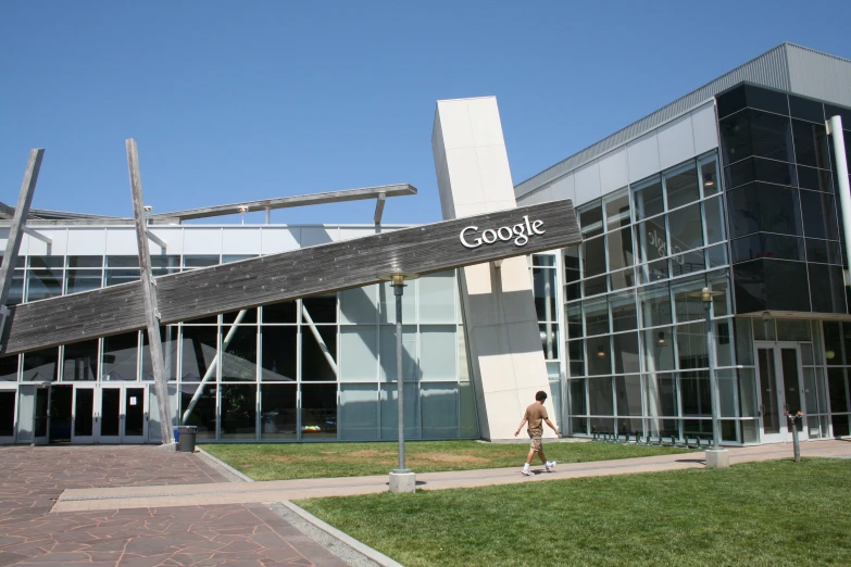 a woman walks down the sidewalk past the building