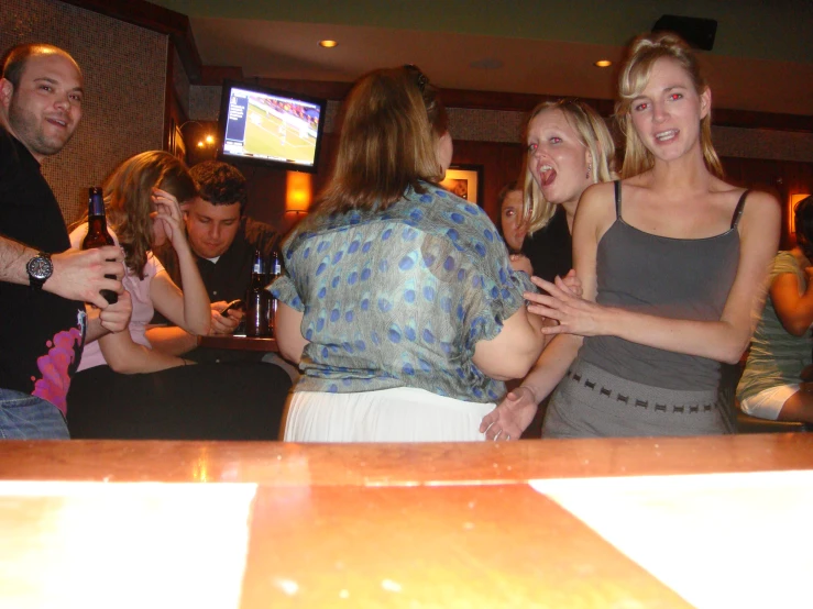 a group of friends are celeting while having a drink