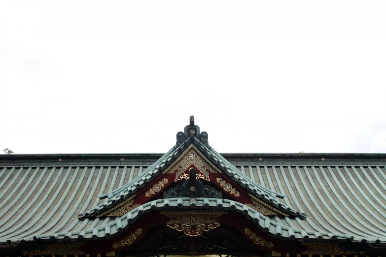 the roof of a japanese temple with a cross on top