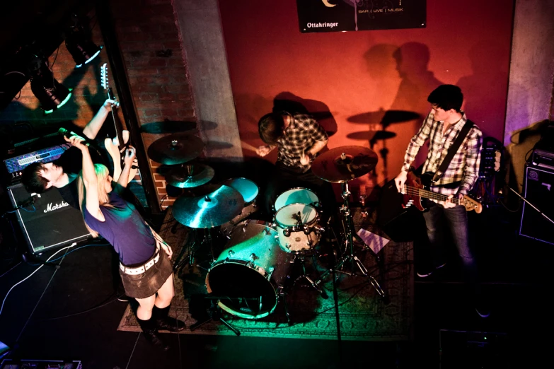 a  playing the drums in front of a band