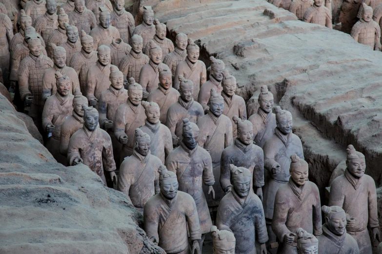 a bunch of statues on the sand and in the middle