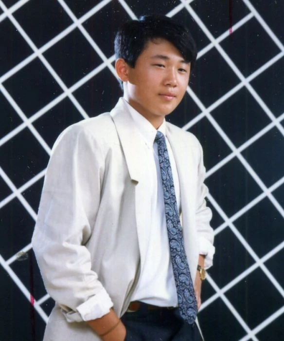 man standing wearing a suit and tie posing for a po
