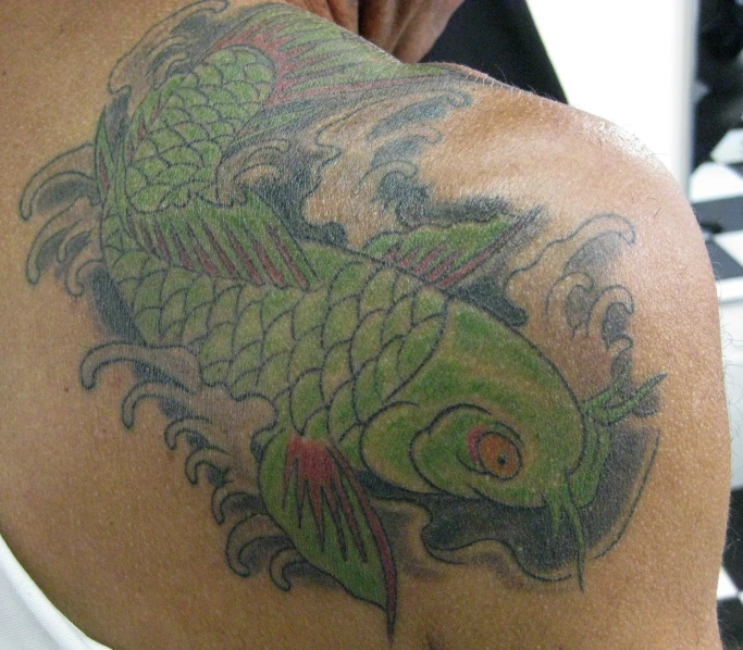 someone with some sort of green lizard tattoo on their back
