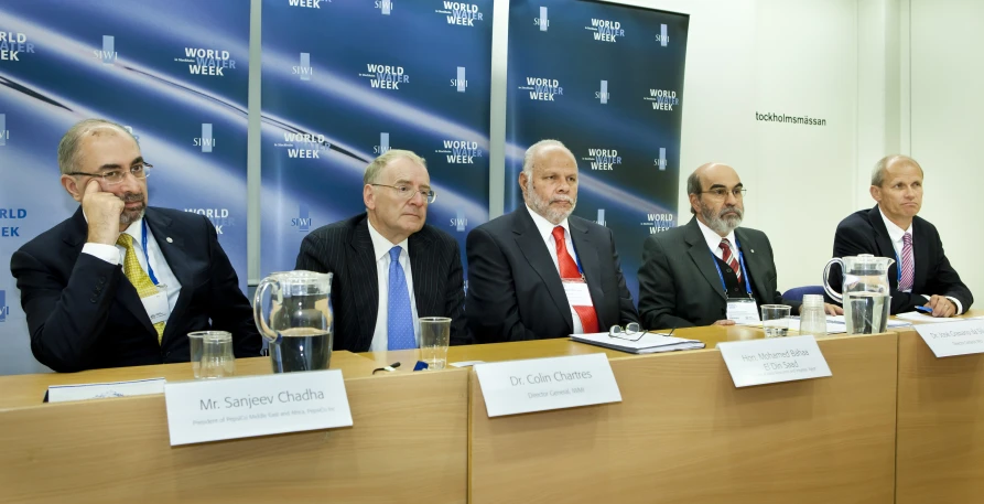 several men are in suits at a conference