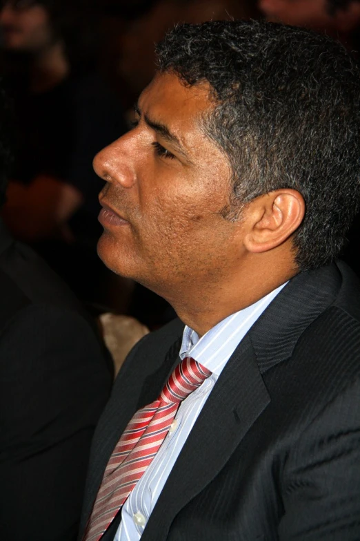 a man in business attire with red and blue necktie