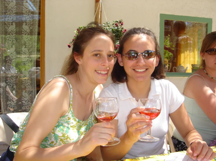 a couple of women that are holding some wine