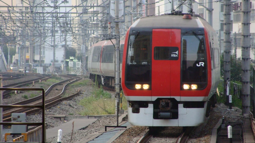 an orange and white train traveling down tracks