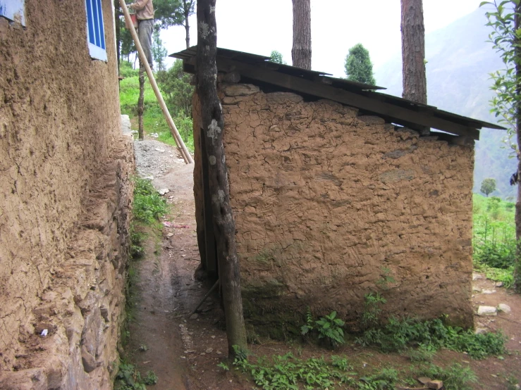 a rustic building along a trail with a wooden sign on it