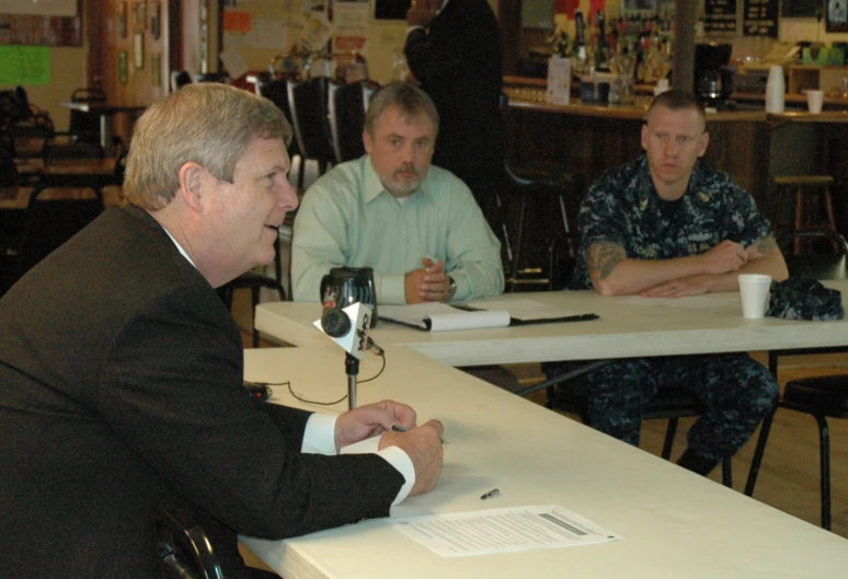 a group of men sitting at tables in a dining room