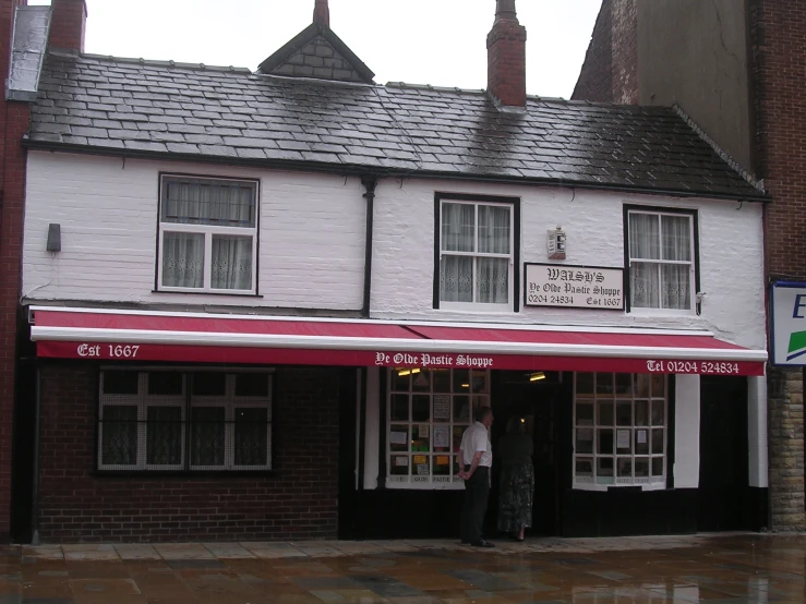 a man in white shirt standing outside of a building