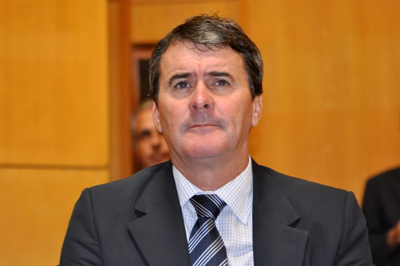 a man in suit and tie sitting down