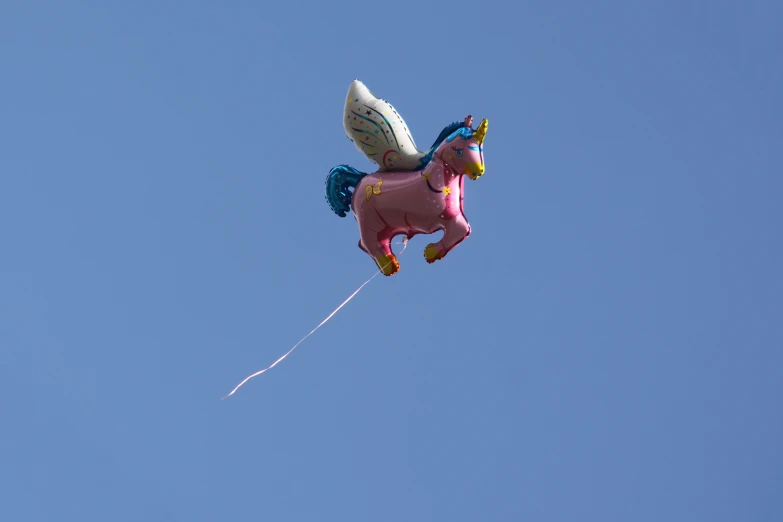 an inflatable unicorn is flying through the air