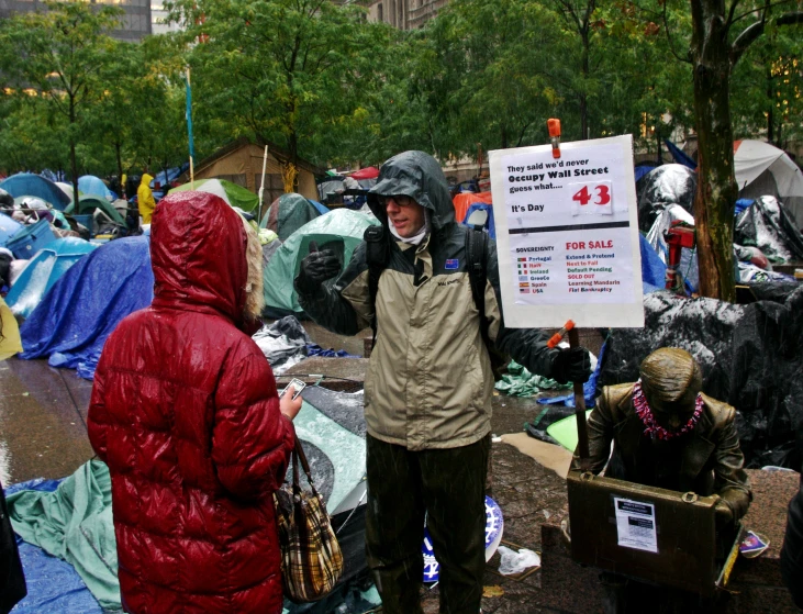 the people stand outside tents with signs