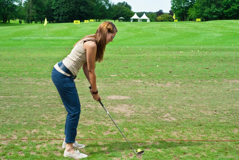 a woman is preparing to hit the ball with her golf club