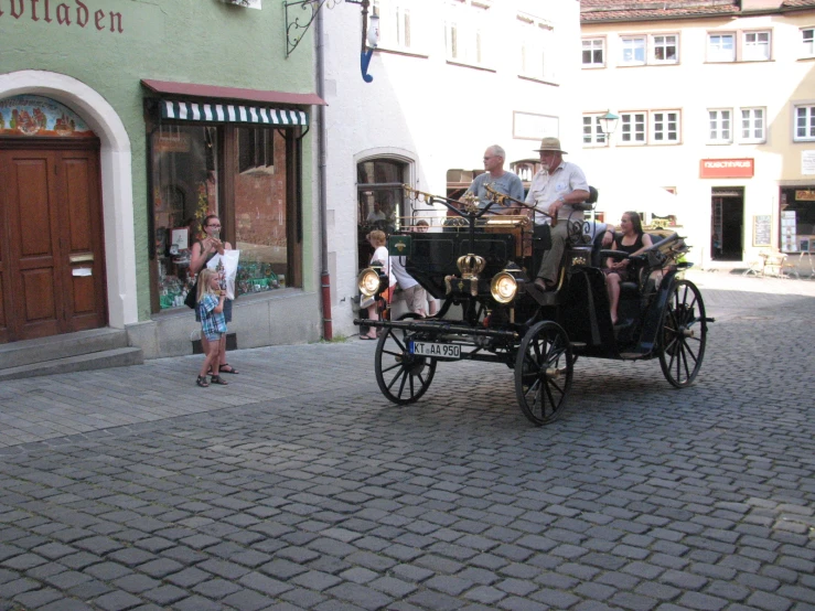 an old - fashioned carriage drives down a cobblestone street