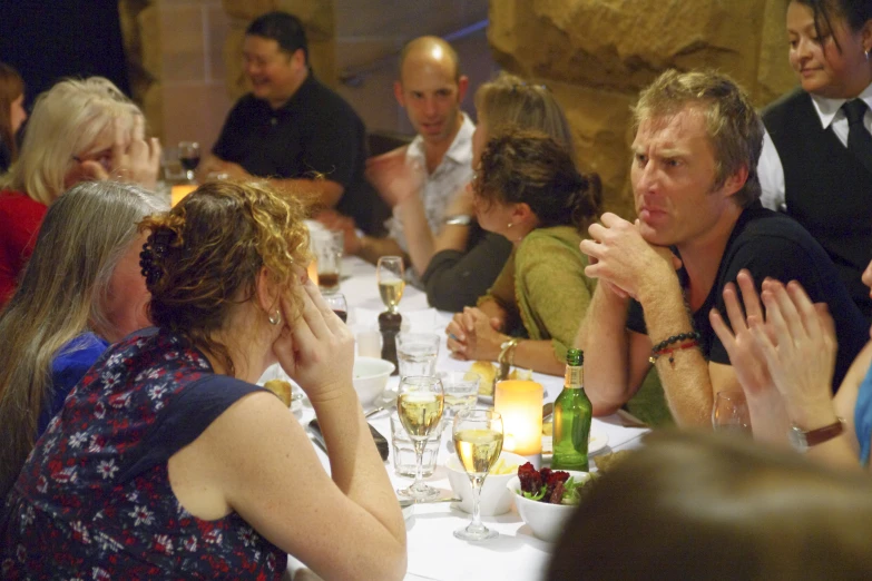 several people sitting at a table and drinking wine