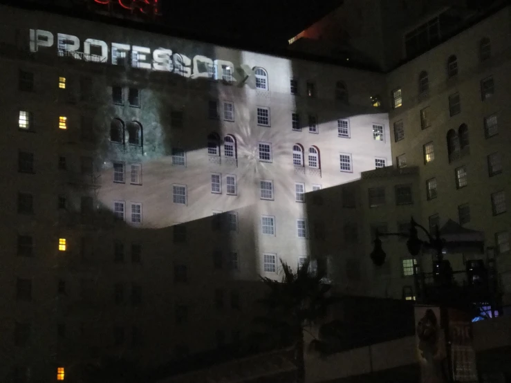 a building with a lit up projection of a cross on it