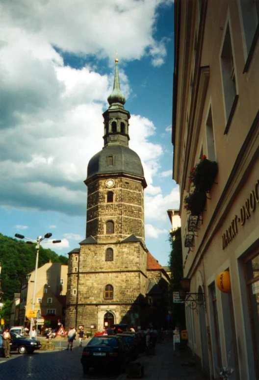 cars parked near buildings with a church on top