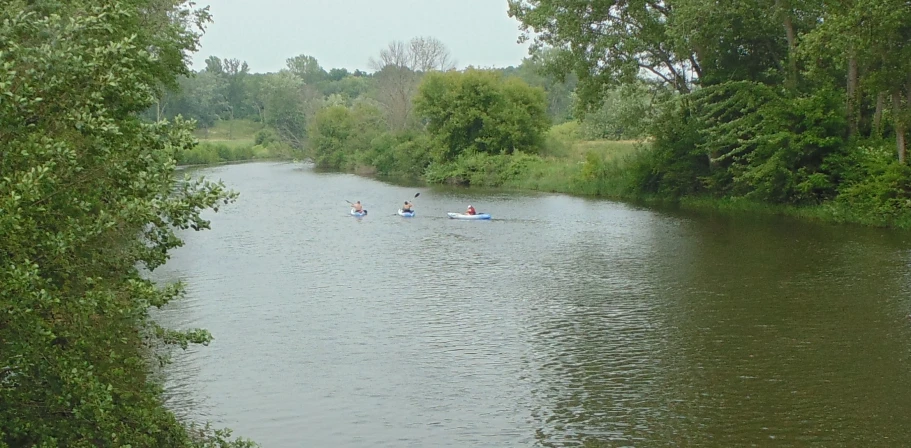 a group of people are on rafts in a pond