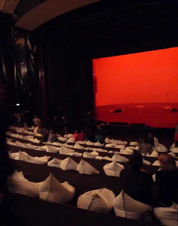 people are watching a movie in a large room with white plastic bags