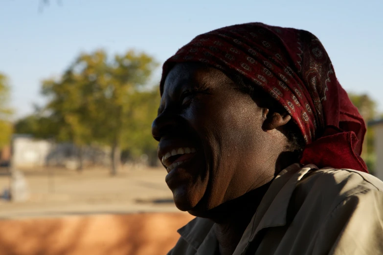 an older person is smiling while standing outside