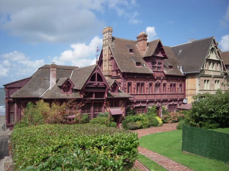 a large house sits on a hill near trees