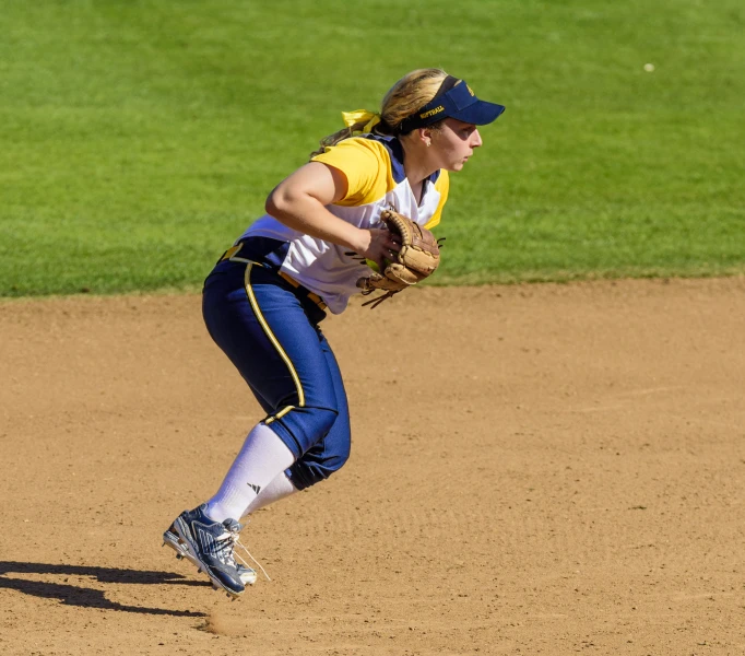 a woman throwing a baseball from the pitchers mound