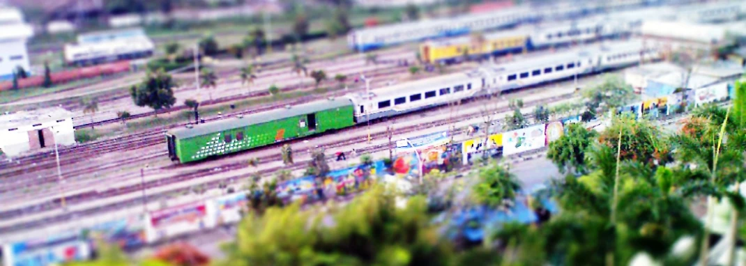 a long green train traveling along a rural country side