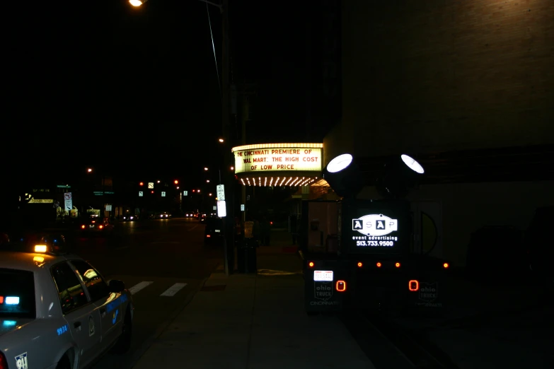 an illuminated sign is displayed on the side of a road