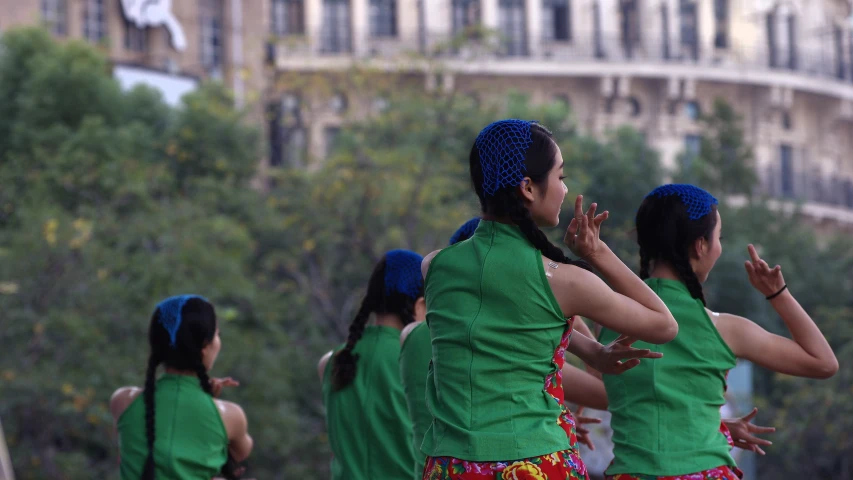a group of girls dance in green shirts
