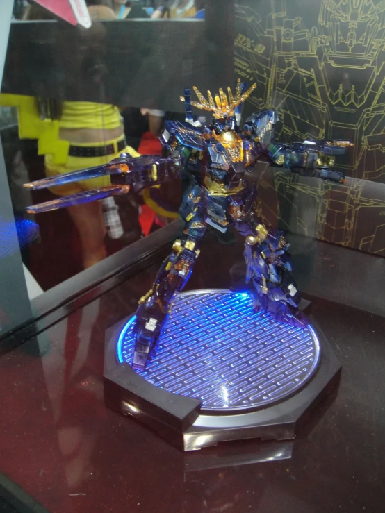 a small statue in a display case with blue and yellow lights