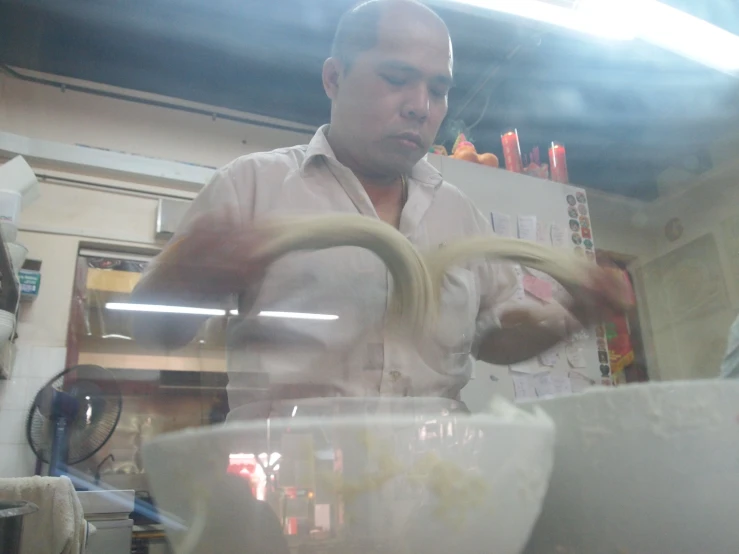 man making some type of dish in a kitchen