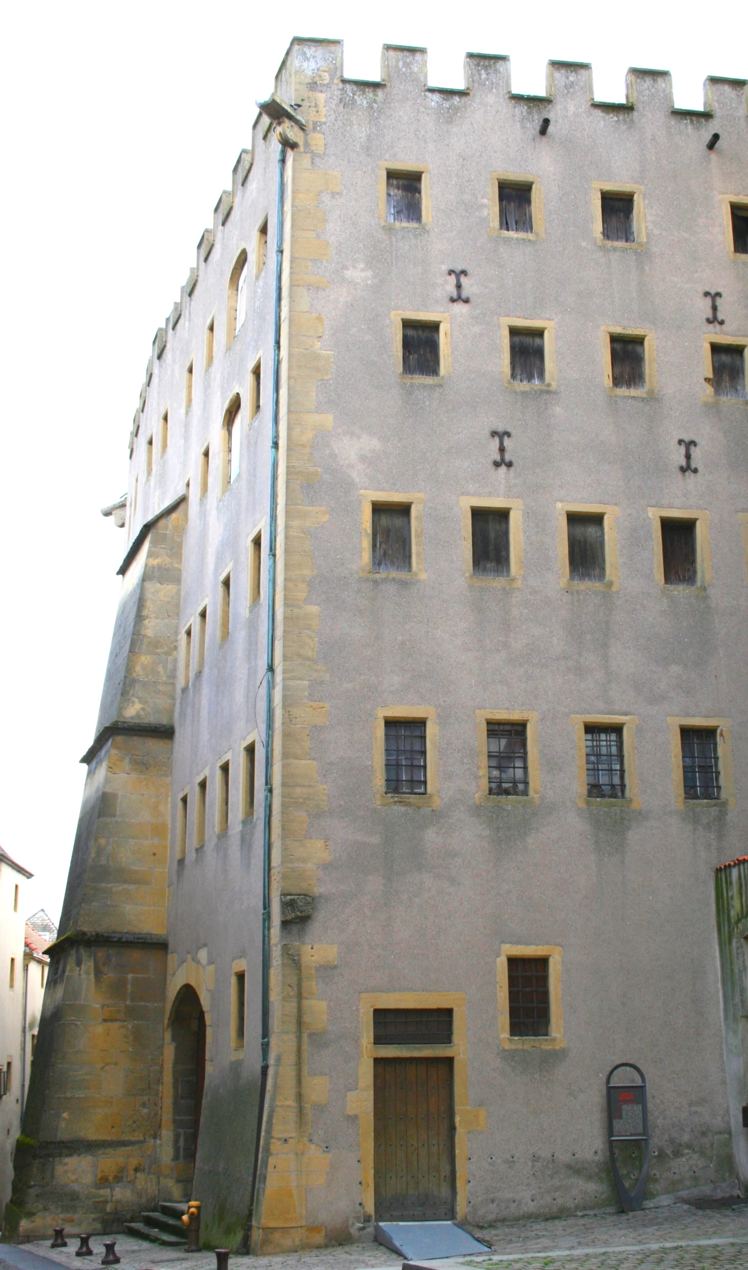 a large stone building with some windows and one window missing