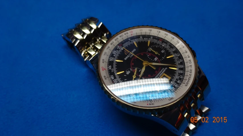 a watch sits on top of the bright blue surface