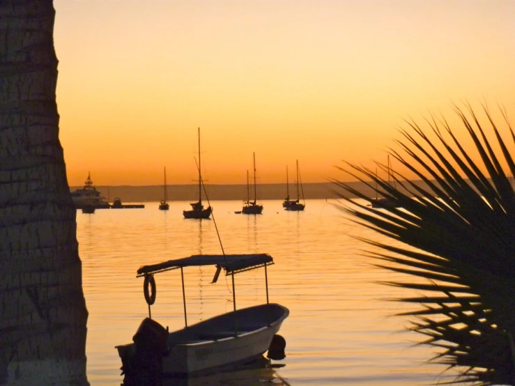 a boat docked on the water at sunrise