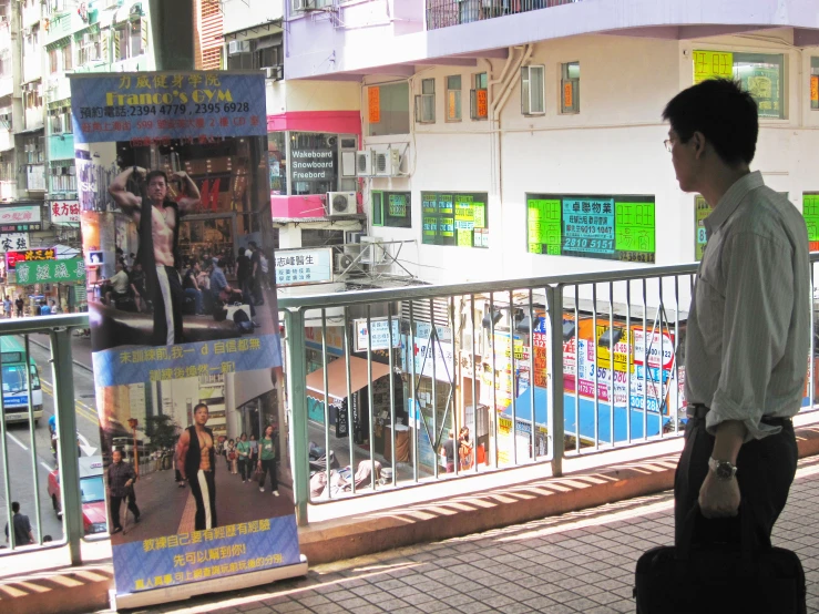 a young man walking down the street past advertits