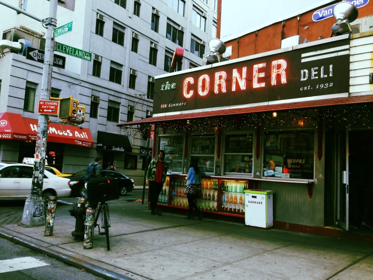 people on bikes are in front of the corner deli