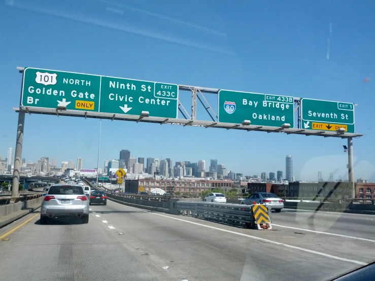 a highway with several green street signs on it