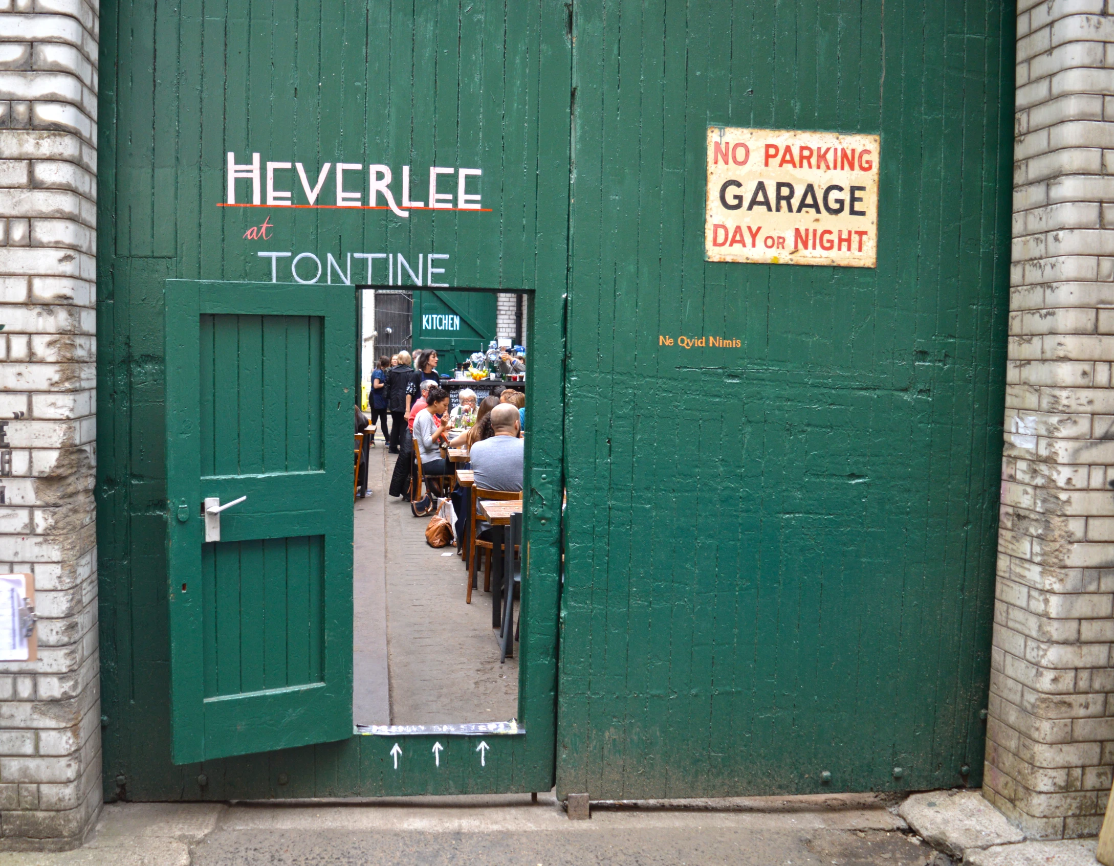 a green garage door is open to reveal a room