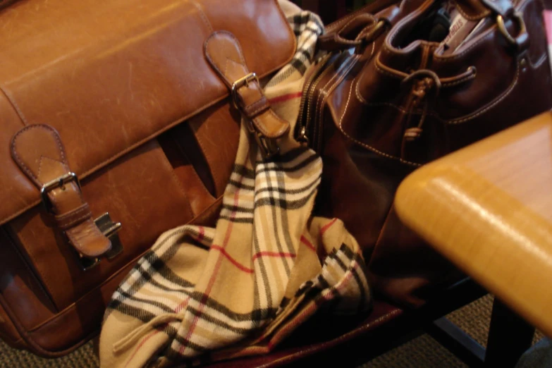 two brown bags on top of a leather chair