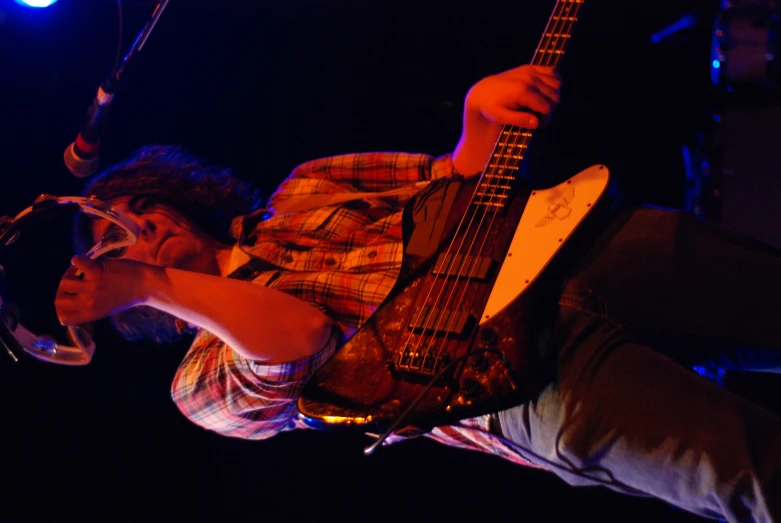 a man on stage holding his guitar up to his face