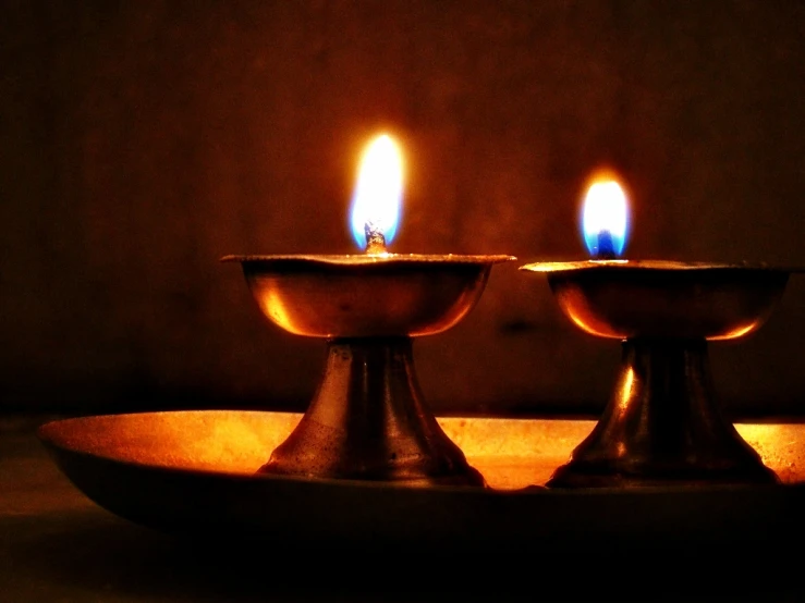 two ss - plated candles in a bowl with brown background